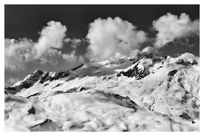 Scenic view of snow covered mountains against sky