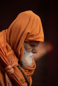 Close-up side view of senior man wearing orange scarf outdoors