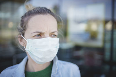 Close-up of woman wearing mask standing outdoors