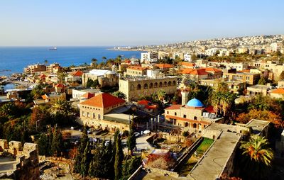 High angle view of townscape by sea against sky