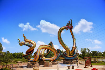  low angle twin stucco painted as a large serpent at pra kai keaw wang nakin,  udon thani, thailand.