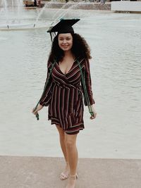 Portrait of smiling young woman wearing mortarboard