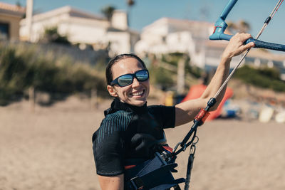 Happy woman kiteboarding at beach on sunny day