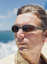 Close-up of man wearing sunglasses at beach on sunny day