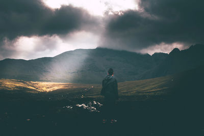 Man standing on mountain against sky