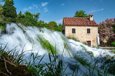 Scenic view of waterfall against sky