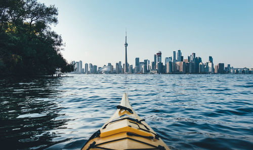 Kayak on lake by city against sky