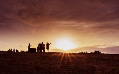 Silhouette people against sky during sunset