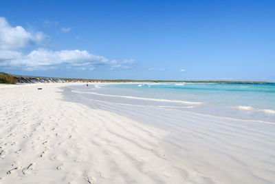 Scenic view of beach against blue sky