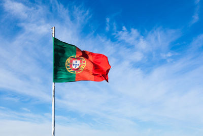 Low angle view of flag against blue sky