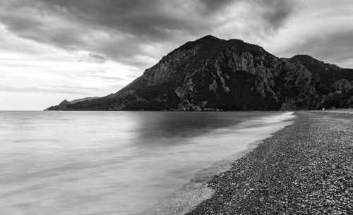 Scenic view of sea and mountains against sky