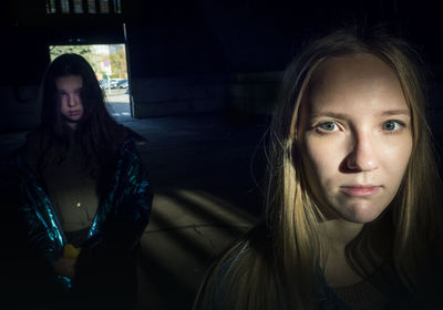 Portrait of young women standing dark room