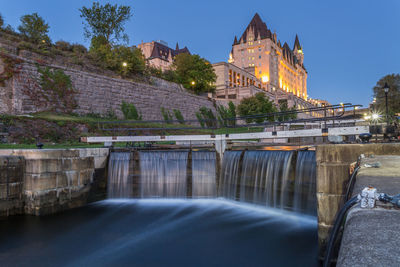 Blurred motion of rideau canal against chateau laurier hotel at dusk