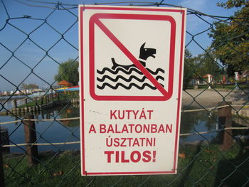 Close-up of warning sign on chainlink fence