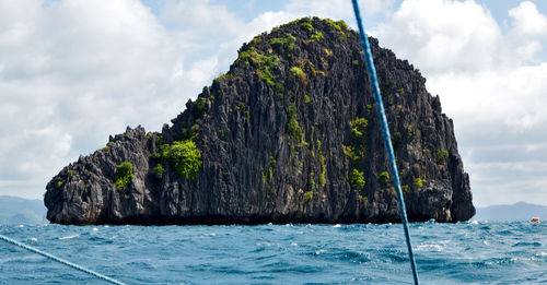 Panoramic view of rock formation by sea against sky