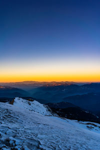 Scenic view of snow covered landscape against sky during sunset