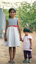 Portrait of cute siblings standing outdoors