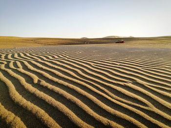 Scenic view of sand dunes against clear sky