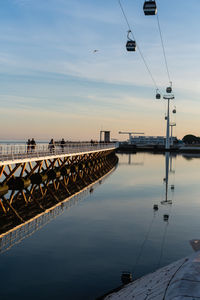 Reflection of street lights on bridge against sky during sunset