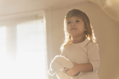 Portrait of cute girl looking away while sitting at home