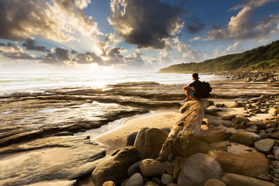 Man looking at sea shore against sky