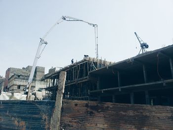 Low angle view of crane against sky