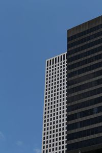 Low angle view of office building against blue sky