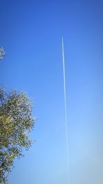 Low angle view of vapor trail against clear blue sky