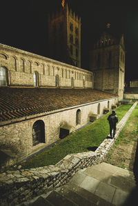 People walking by historic building at night