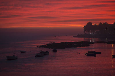 View of boats in calm sea at sunset