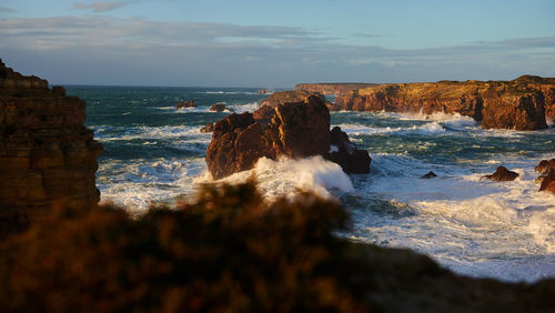 Rocks in sea against sky