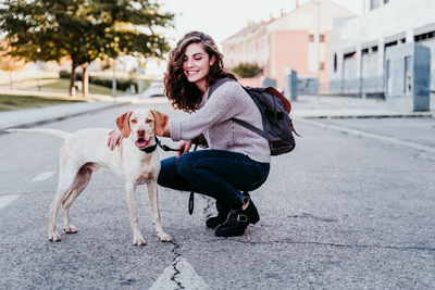 Portrait of woman with dog in city