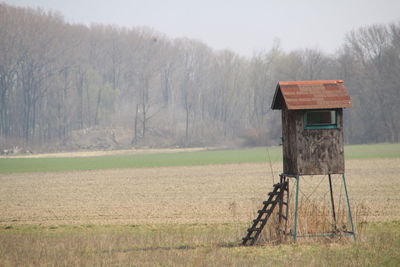 Lifeguard hut on field against trees