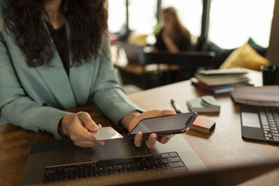 Woman's hands holding cell phone and credit card