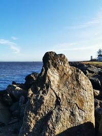 Rocks by sea against sky