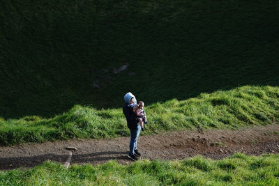 Rear view of woman walking on field