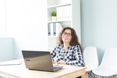 Mid adult woman using laptop on table