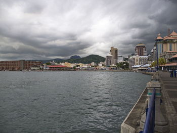 Buildings in city against cloudy sky