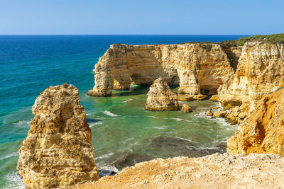 Panoramic view of rocks on beach against clear sky