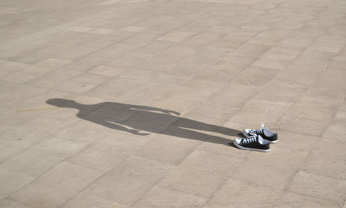 Shoes with human shadow on ground