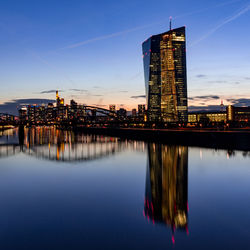 Reflection of buildings in city at dusk