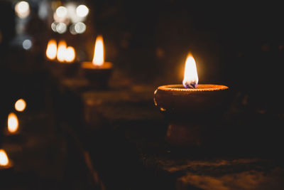 Close-up of lit candle in the dark