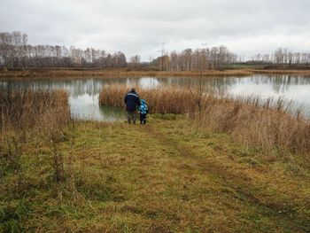 Rear view of man on lake against sky