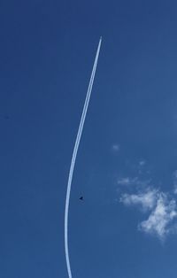 Low angle view of vapor trail against blue sky