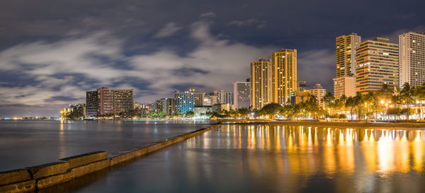 Illuminated buildings in city against sky at night