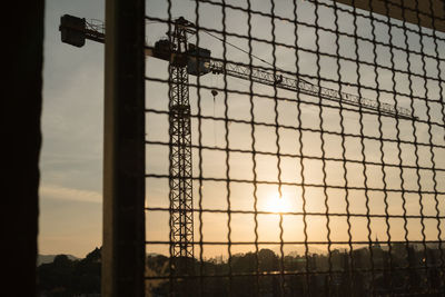 Low angle view of silhouette fence against sky during sunset