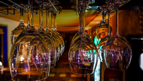 Close-up of wineglasses hanging at bar