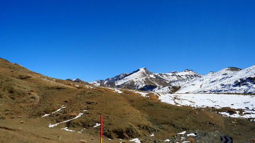 Scenic view of snowcapped mountains against clear blue sky