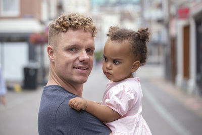 A red head father holding his daughter