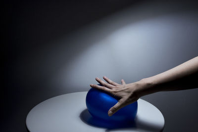 Close-up of woman pressing ball gray background